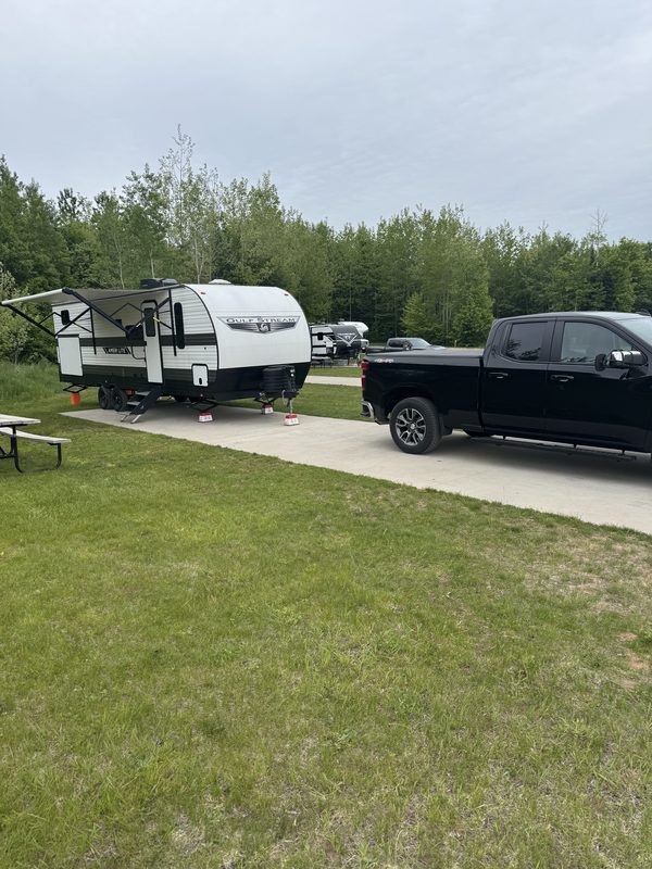 Travel trailer and pickup truck at a campsite near Munising